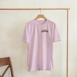 Pink crew-neck t-shirt featuring a small Urban Palm Trees retro logo on the chest, hanging on a wooden clothing rack.