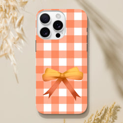 Orange gingham iPhone case with a 3D ribbon bow. Cute coquette tough cover with impact-resistant shielding for daily commutes.