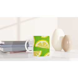Cute Lemon Slice Mug with citrus print, a white ceramic coffee cup on a desk beside notebooks.