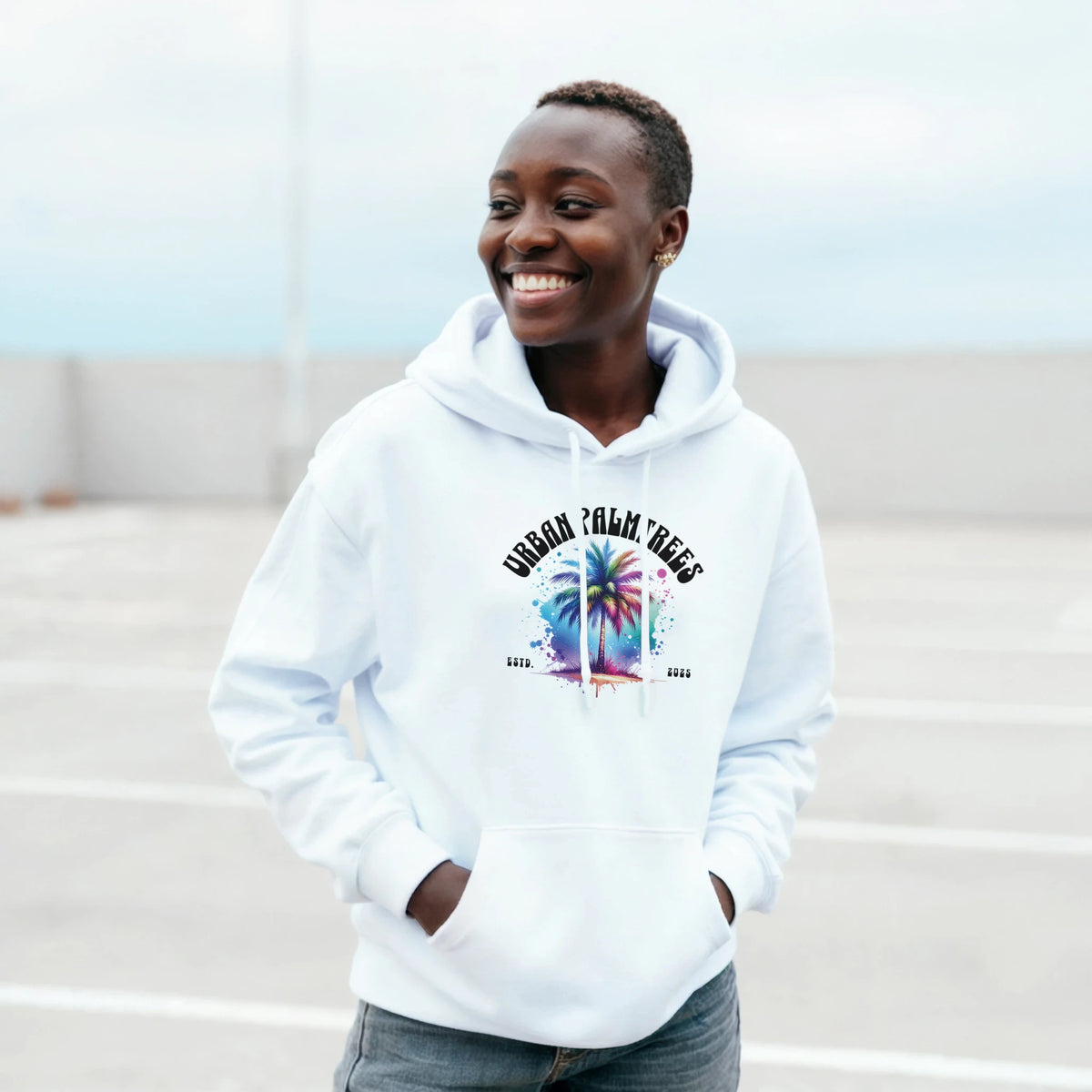 Person wearing a white Urban Palm Trees hoodie with a colorful palm-tree graphic.