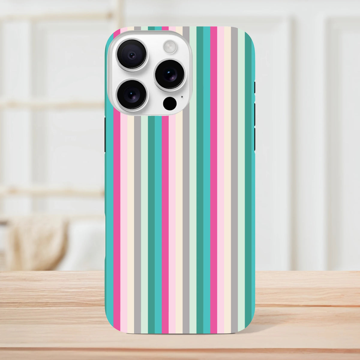 Retro pink and aqua vertical stripe tough iPhone case compatible with models 13 through 16 on a wooden surface.