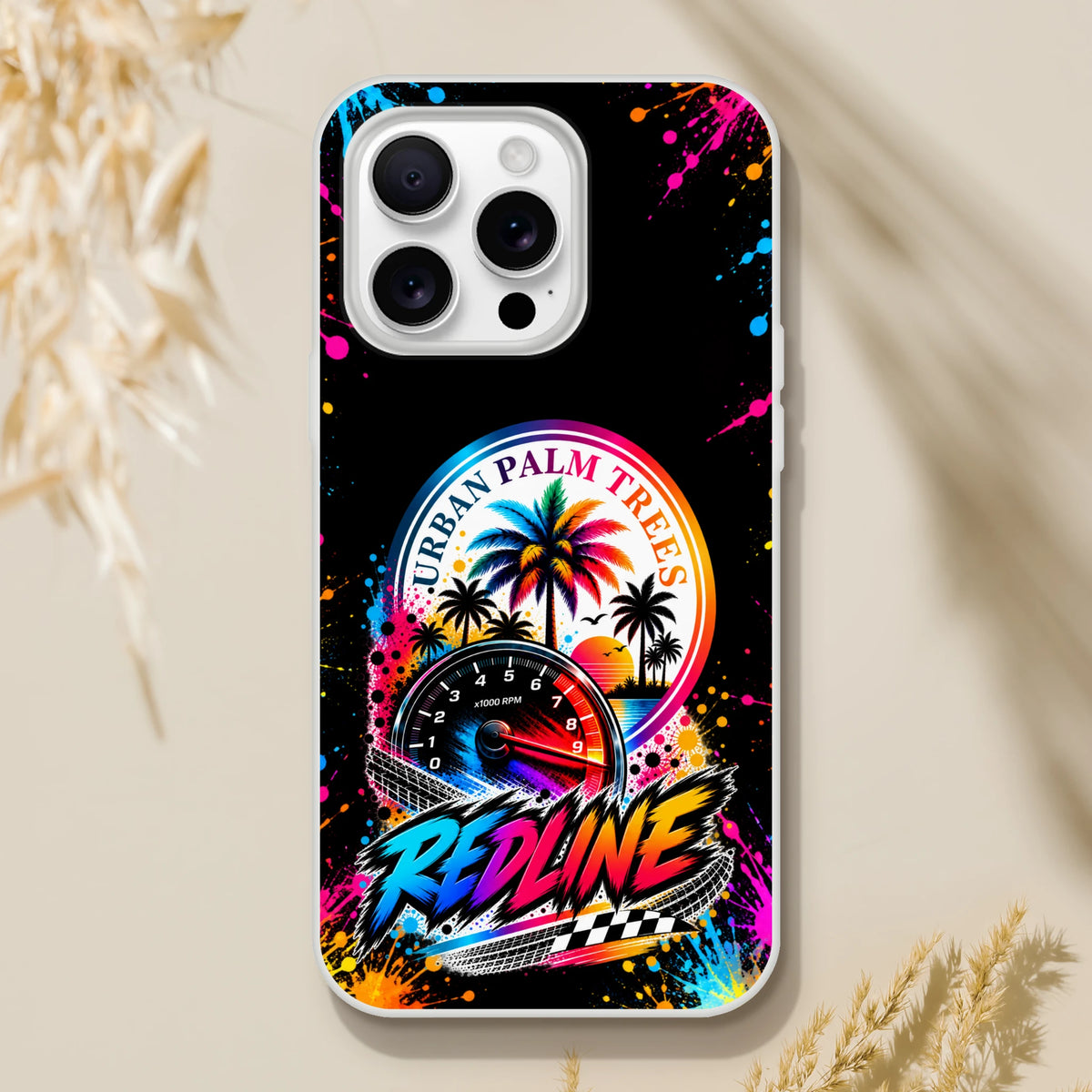Vibrant Redline iPhone case featuring urban palm trees, RPM gauge, and colorful paint splatter on matte black background.
