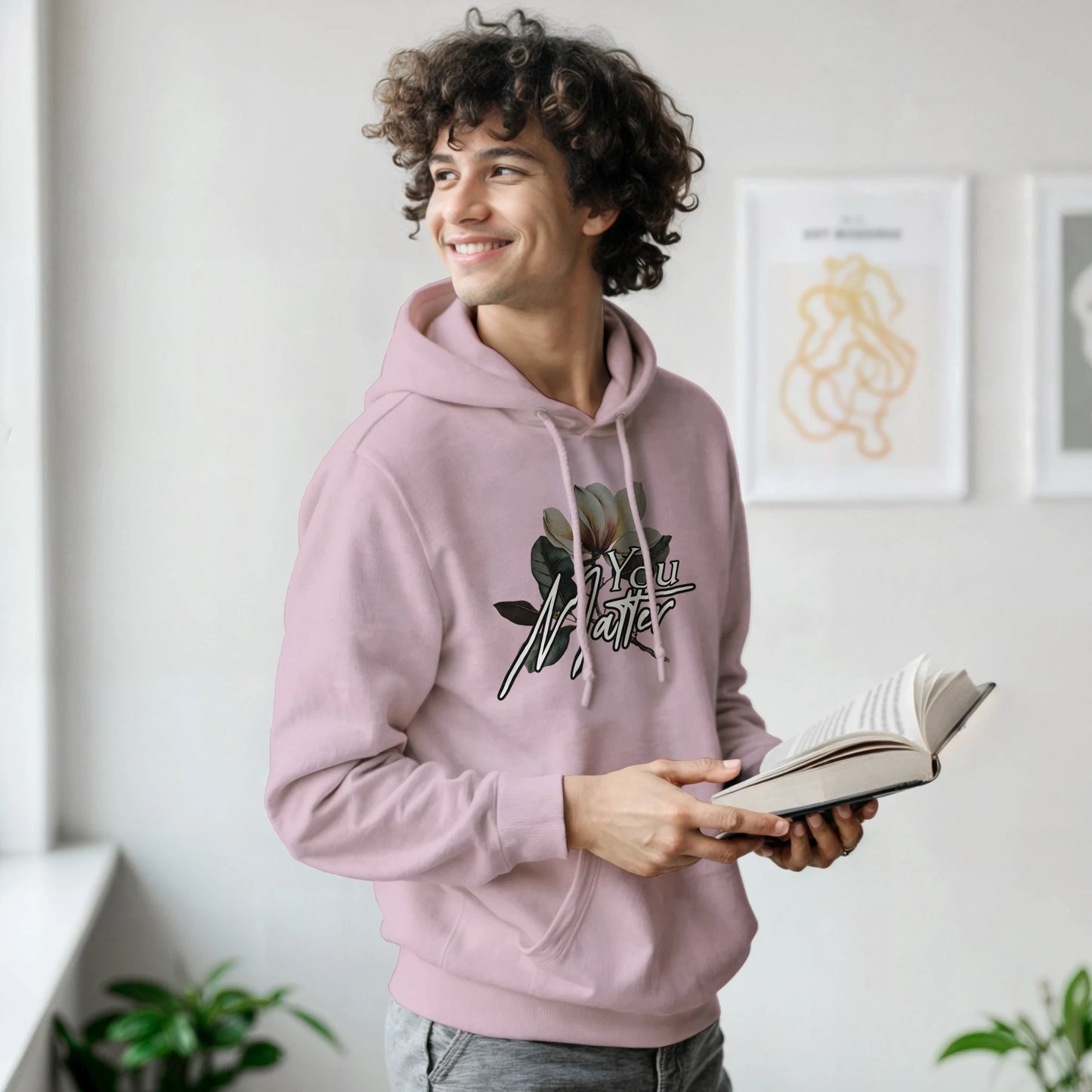 Man in pink You Matter hoodie with floral graphic, front pouch pocket, soft cotton-poly blend.