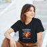 Woman wearing a black California Beach Paradise graphic T-shirt with palm trees and sunset.