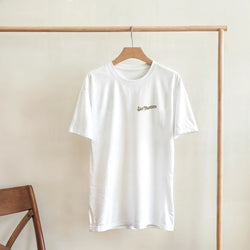 White San Francisco graphic T-shirt on a wooden hanger with small gold San Francisco text.