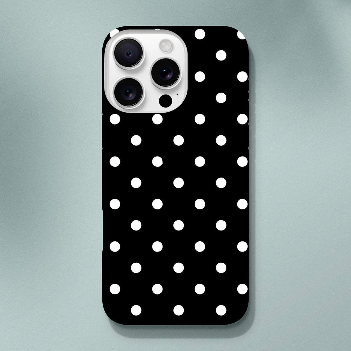 Black and white polka dot tough iPhone case featuring a glossy finish and shock-absorbing TPU core for durable protection.
