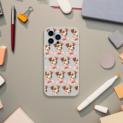 Clear iPhone case with a repeating pattern of brown-and-white puppies wearing pink bows.