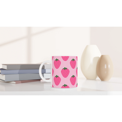 Cute pink strawberry mug with kawaii fruit design on a white desk