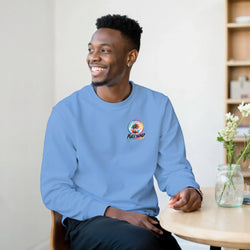 Man wearing light blue Full Send sweatshirt with small palm tree chest logo, seated at a table with flowers.