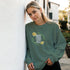 Green women's graphic sweatshirt with floral wreath and Good Vibes Only text, soft cotton blend.
