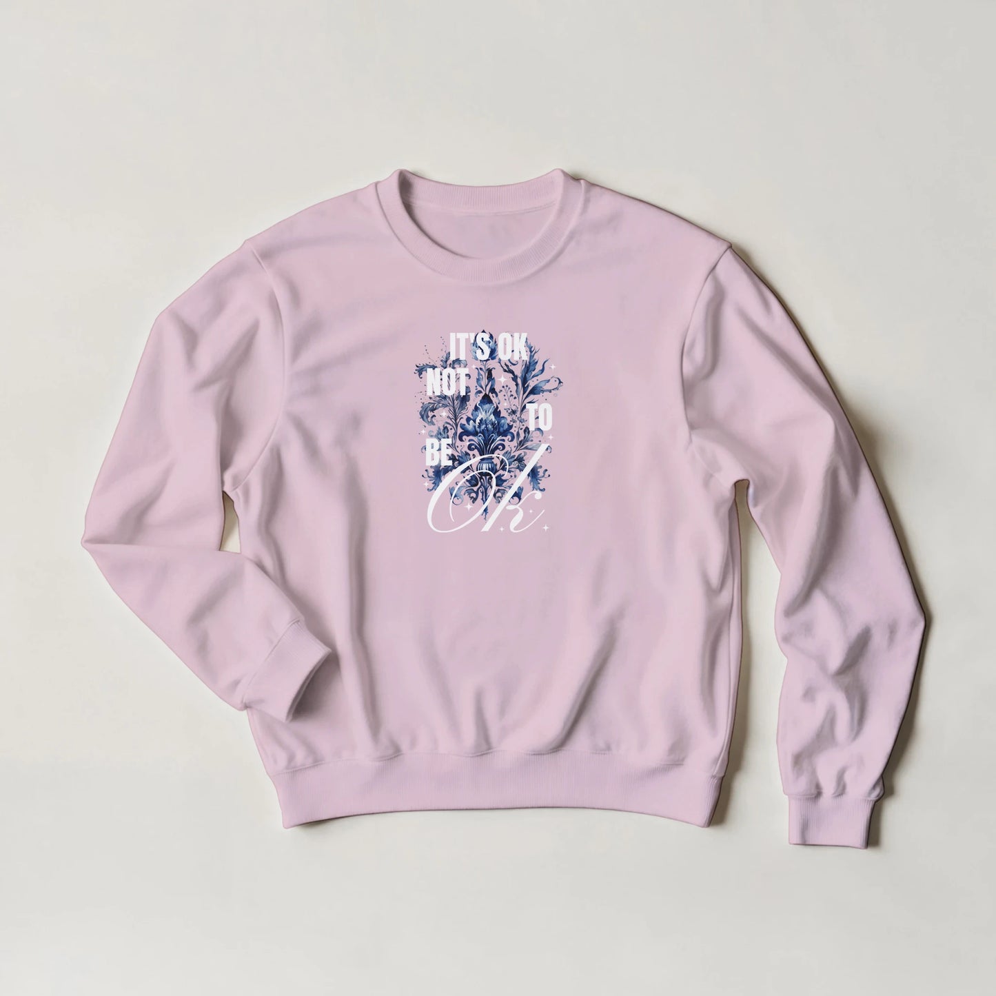 Pink women's mental health graphic sweatshirt with blue floral design and 'It's OK Not To Be OK' text.