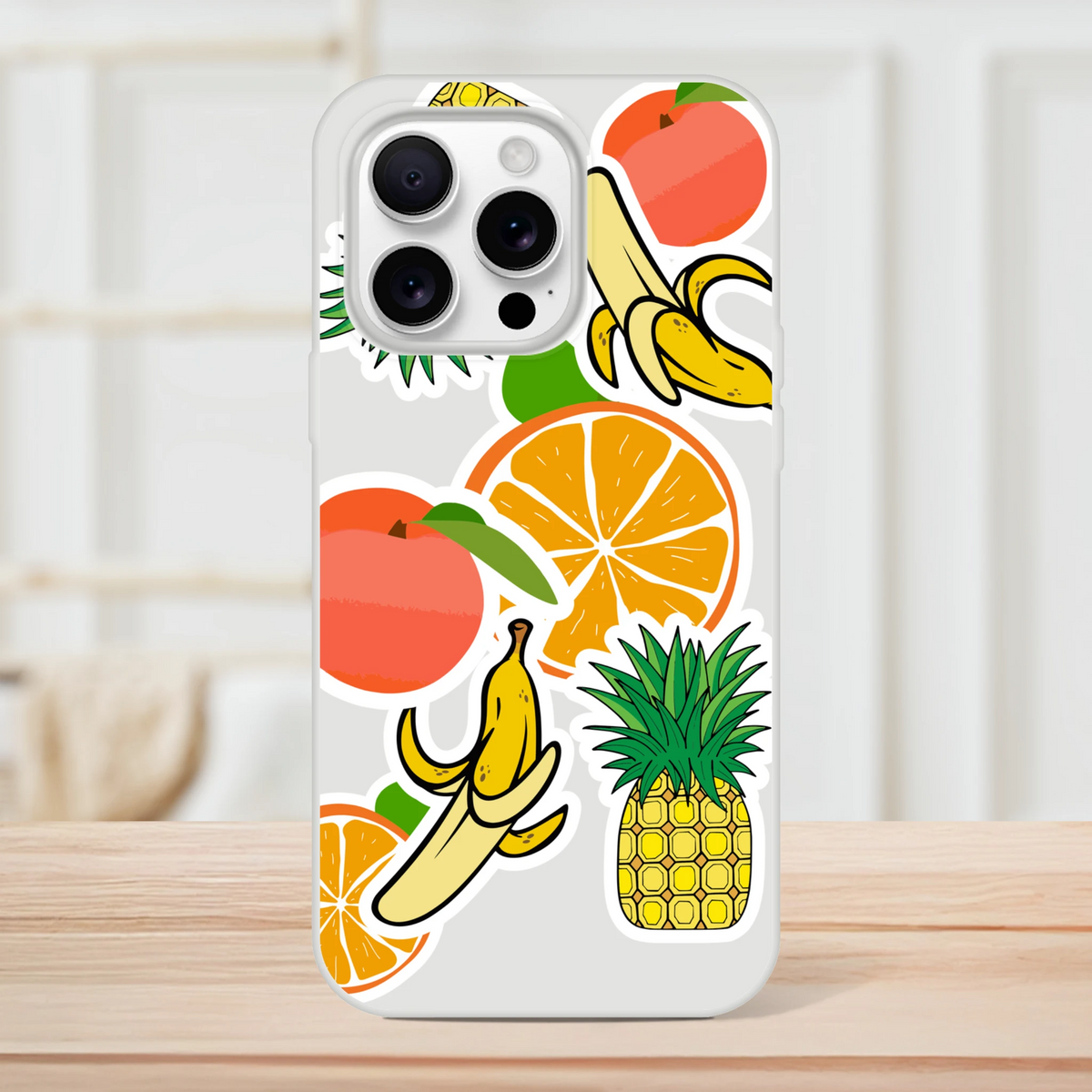 Clear iPhone case featuring bold tropical fruit sticker graphics of oranges, bananas, and pineapples for a vibrant streetwear look.
