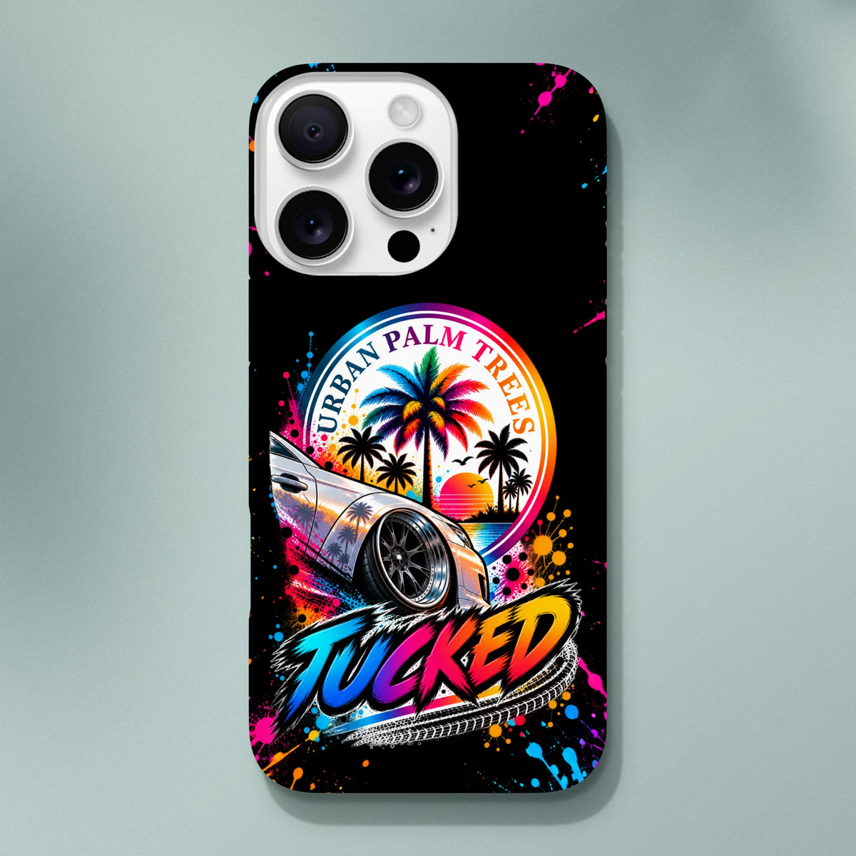 iPhone case featuring a lowered modified car, rainbow palm trees, and colorful "TUCKED" lettering with paint splatters on black.