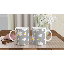 Ditsy Daisy mugs with white and yellow daisies on gray, placed on a checkered tablecloth.