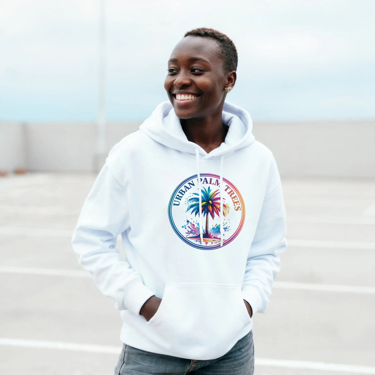 Smiling person wearing a white Urban Palm Trees hoodie with a retro streetwear palm tree graphic.