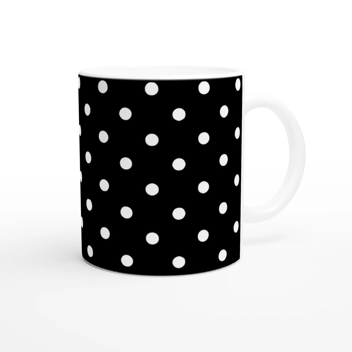 Black ceramic mug with white polka dots and white handle. Vintage spotty coffee cup for daily brews or gifting.