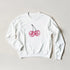 White crewneck sweatshirt featuring pink glittery cherry graphic in a pastel Y2K-inspired style.