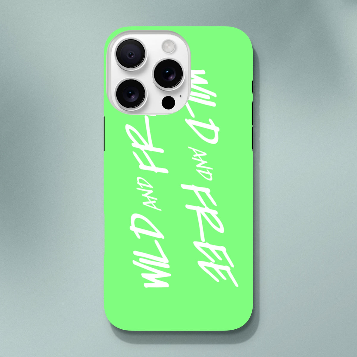 Lime green iPhone case featuring repeated white "Wild and Free" handwritten text in a Y2K aesthetic tough phone cover.