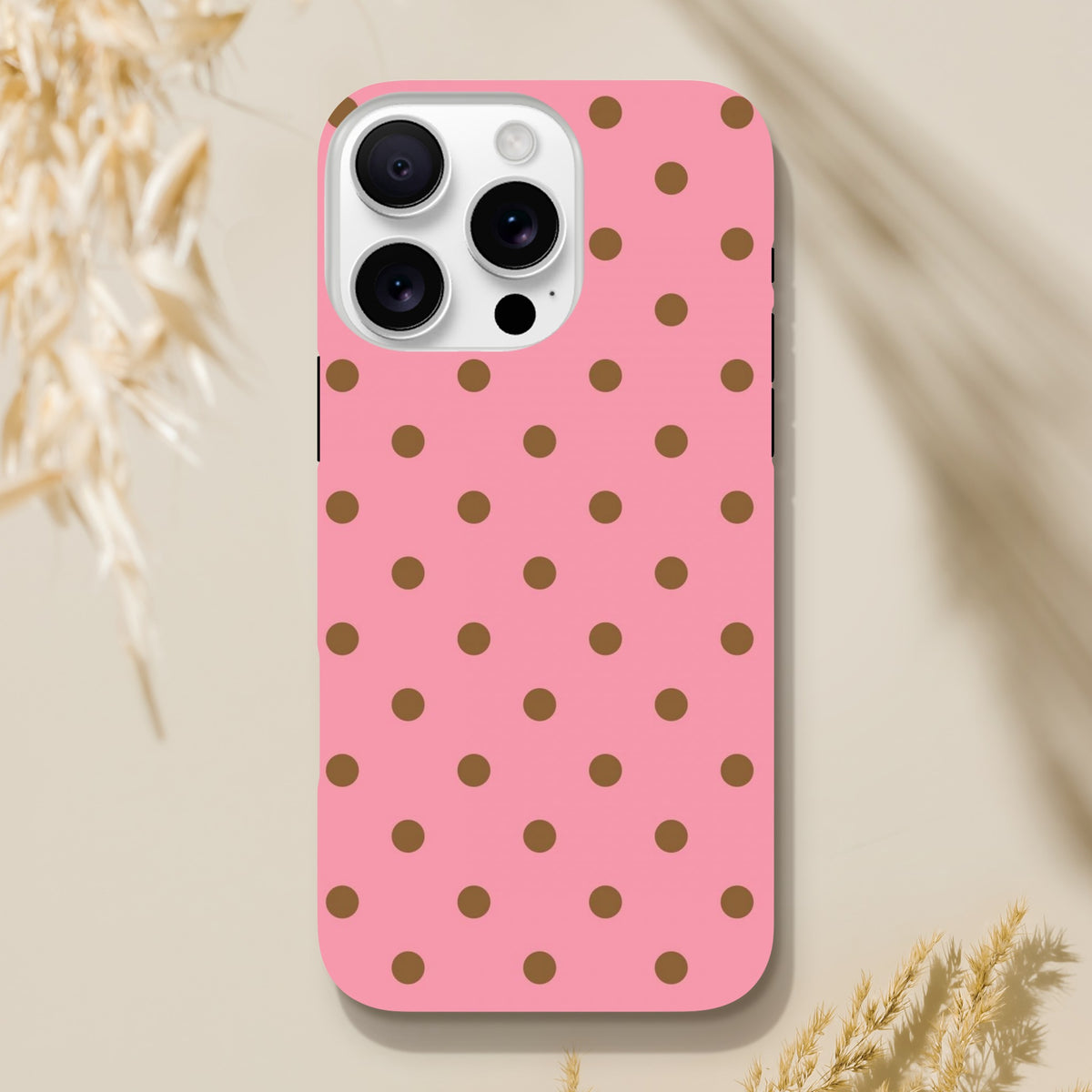 Pink and brown polka dot tough iPhone case with glossy finish, designed for shock absorption and durable daily protection.