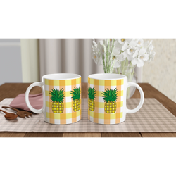 Two pineapple-gingham mugs with yellow patterns on a table, vibrant summer coffee cups