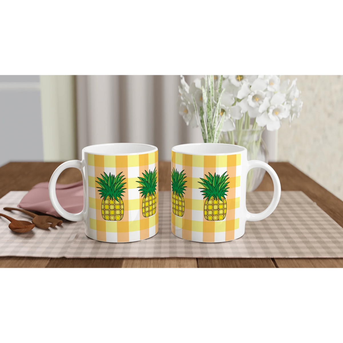 Two pineapple-gingham mugs with yellow patterns on a table, vibrant summer coffee cups
