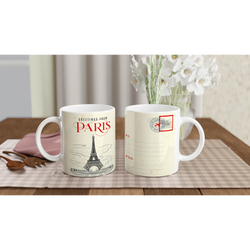 Two Vintage Paris mugs featuring postcard designs and Eiffel Tower motifs on a checkered table with flowers.