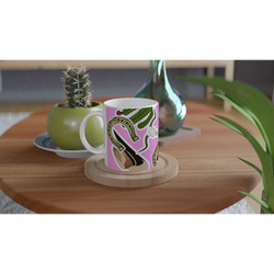 Pink Western ceramic mug featuring boots, cactus, and horseshoe design sitting on a wooden coaster.