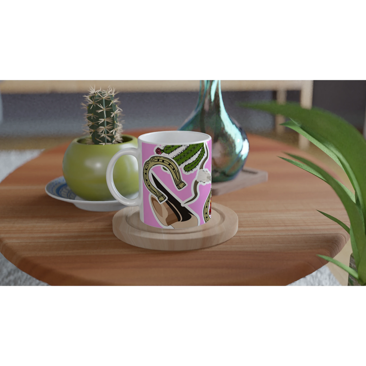 Pink Western ceramic mug featuring boots, cactus, and horseshoe design sitting on a wooden coaster.