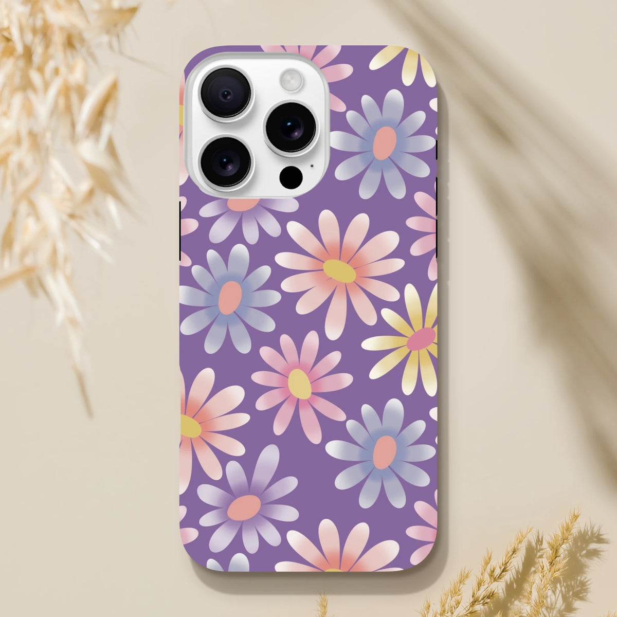 Purple retro floral iPhone case featuring pastel daisies in pink, yellow, and blue on a shock-absorbing TPU cover.