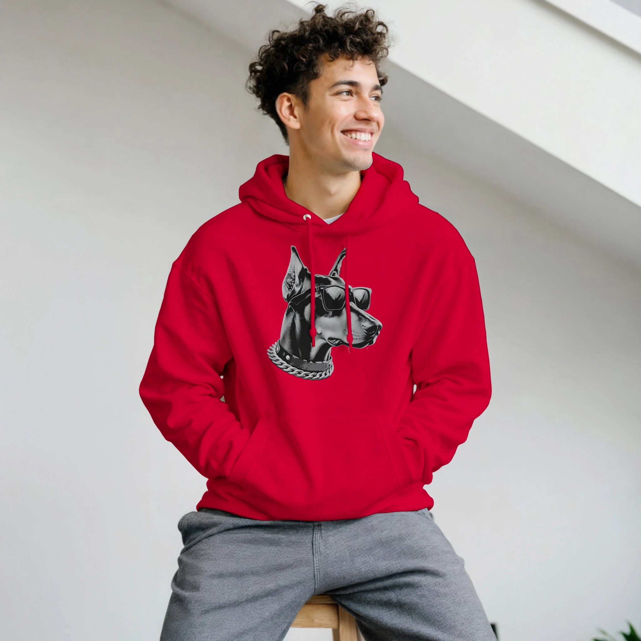 Man in a red Gangster Dog Jumper hoodie featuring a black-and-white dog head with sunglasses and a chain.