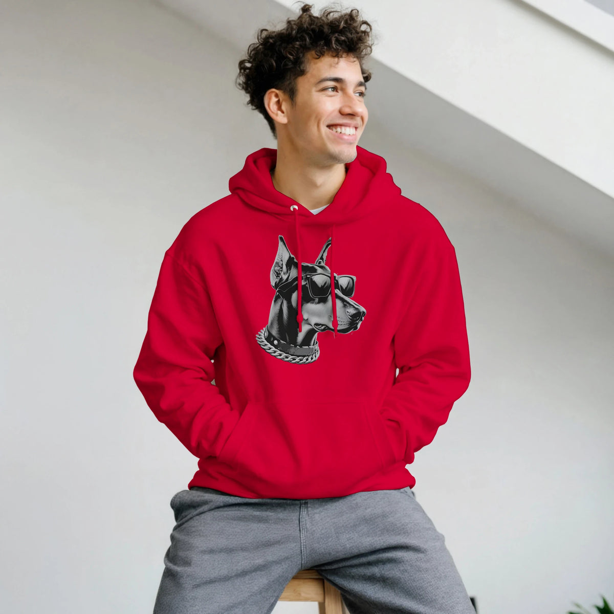 Man in a red Gangster Dog Jumper hoodie featuring a black-and-white dog head with sunglasses and a chain.