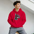 Man in a red Gangster Dog Jumper hoodie featuring a black-and-white dog head with sunglasses and a chain.
