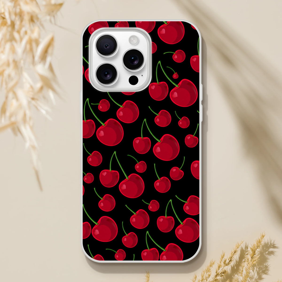 Black iPhone case featuring a scattered retro red cherry pattern with green stems and white bumper.