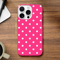 Hot pink and white polka dot tough iPhone case with rugged dual-layer protection and shock-absorbing TPU on a wooden desk.