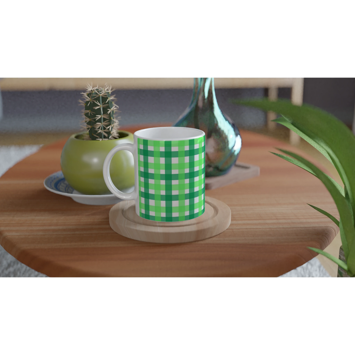 Green gingham ceramic mug with white handle on a wooden table beside a small cactus and green vase.