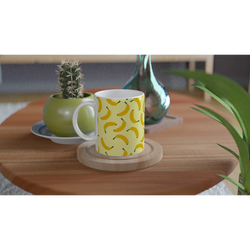 Cute banana-pattern mug with a yellow banana motif on a wooden table beside plants.