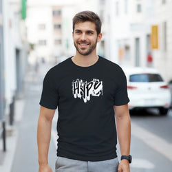 Urban Graffiti Graphic T-Shirt for Men worn by a man in black with bold white graffiti artwork against a city street backdrop