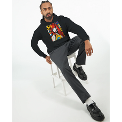 Man wearing black streetwear hoodie featuring a bold retro pop art woman graphic with red hair and colorful circles.