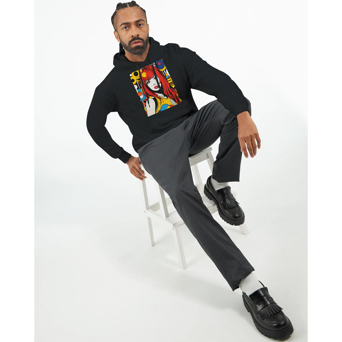 Man wearing black streetwear hoodie featuring a bold retro pop art woman graphic with red hair and colorful circles.