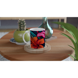 Colourful tropical hibiscus mug with vibrant floral design on a wooden table beside a cactus.