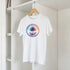 Retro palm tree T-shirt on hanger in closet with a rainbow circular palm tree graphic.