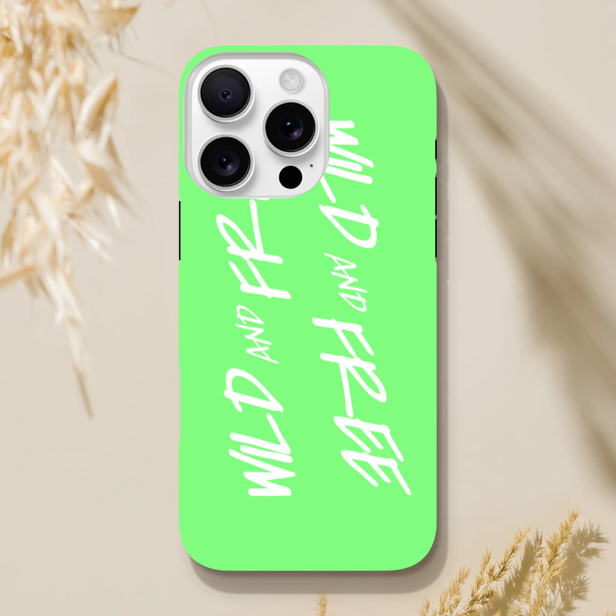 Lime green iPhone case with white Wild and Free Y2K slogan text and tough shock-absorbing shell design.