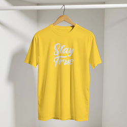 Yellow Cute Stay True T-shirt on wooden hanger in closet with white retro slogan.