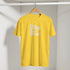 Yellow Cute Stay True T-shirt on wooden hanger in closet with white retro slogan.