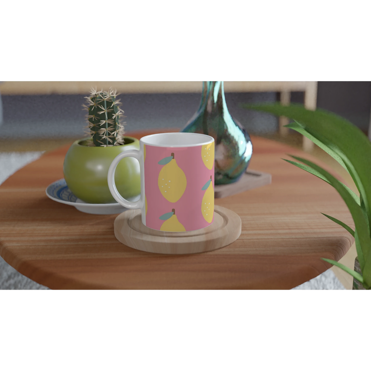 Pink lemon-pattern ceramic mug on a wooden table with a cactus and greenery in the background.