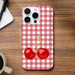 Cute red and white gingham iPhone case featuring two bright red cherries, designed for drop protection on iPhone 13-16 models.