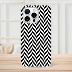 Black and white herringbone iPhone case standing on wood. Geometric chevron phone cover with matte finish and shock-absorbing TPU protection.