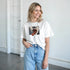 Woman wearing white T-shirt with square Pop Art Lips graphic print; soft cotton blend.
