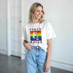 Woman wearing white Pride LGBTQ short-sleeve graphic tee with rainbow block and ampersand, Peace & Pride design.