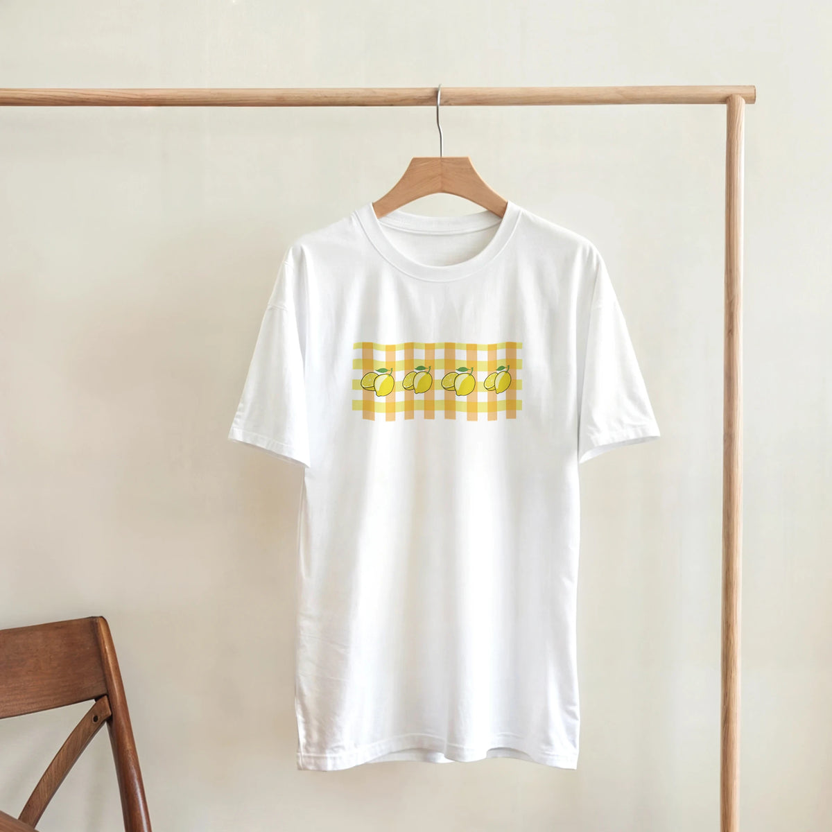 White women's Lemon Gingham T-Shirt on a hanger featuring a lemon print inside a yellow gingham block.